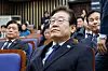 Democratic Party leader Lee Jae-myung watches news of President Yoon Suk Yeol's arrest by the Corruption Investigation Office for High-ranking Officials while attending a meeting of lawmakers held at the National Assembly in Yeouido, western Seoul, on Jan. 15. [NEWS1]