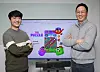 Na Young-chae, left, and Lee Chin-ho, co-CEOs and founders of Supergene, stand before a screen featuring Supergene's social game 'The Puzzle' at its office in Pangyo, Gyeonggi. [PARK SANG-MOON]