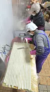Owners of a tteok (sticky rice cake) shop in the Dongmun Traditional Market in Jeju are making bar-shaped rice cakes on Monday, three days before Lunar New Year. [YONHAP]