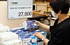 A customer looks at a box of disposable face masks made in Korea at an Emart store. [EMART]