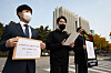 Korea Indoor Sports Facilities Association spokesperson Park Joo-hyung, center, announces that 350 gym owners and employees are suing the government on Thursday. [NEWS1]