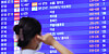 A traveler checks flight schedules on an electric board at Incheon International Airport Terminal 1 on Thursday. [YONHAP]