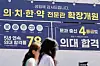 People pass by a flyer advertising medical school admissions in Daechi-dong, Gangnam District, in southern Seoul, in April. [NEWS1]