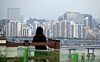 A woman looks at apartments in an area south of the Han River on Wednesday. [YONHAP]