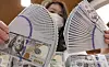 An employee fans dollar bills at Hana Bank's foreign currency forgery and alteration response center in Jung District, central Seoul, on March 27. [YONHAP]