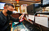 A restuarant owner in Seoul looks at a list of reservations that have been cancelled as a result of the tightened social distancing regulations on Thursday. [YONHAP]