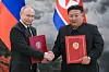 Russian President Vladimir Putin and North Korean leader Kim Jong-un hold two copies of the new treaty between the two countries after signing them in Pyongyang, June 19. [TASS/YONHAP]