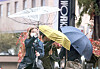 Strong winds during a rainstorm turned an umbrella inside out while people hold their umbrellas as they walk at Gwanghwamun Square in central Seoul on Monday. [YONHAP]