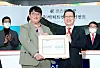 Big Hit Entertainment Chairman Bang Si-hyuk, left, and Korea Exchange CEO and Chairman Jung Ji-won pose for a photo holding a memorial tablet celebrating the company's public listing on Oct. 15 at the exchange's headquarters in Yeouido, western Seoul. [BIG HIT ENTERTAINMENT]