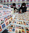 Employees arrange Christmas seals at the Korea National Tuberculosis Association's Gyeonggi office in Suwon on Wednesday. This year's Christmas seals will feature various personas comedian Yoo Jae-suk took on during his TV show 'Hangout with Yoo,' such as trot singer Yoo San-seul and entertainment agency head Jimmy Yoo. [YONHAP]