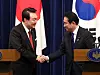 President Yoon Suk Yeol, left, shakes hands with Japanese Prime Minister Fumio Kishida at the end of their joint news conference after their summit in Tokyo on March 16. [YONHAP]