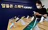 A customer looks at a smartphone displayed at a mobile virtual network operator service center in Seoul. [NEWS1]