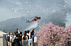 Hikers watch a helicopter put out a fire that broke out on Mount Inwang in Jongno District, central Seoul on Sunday. [YONHAP]