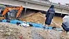 An excavator stacks up sand on a temporary levee next to the Miho River on Friday. The levee on Saturday morning broke, flooding a nearby underpass where nine people were found dead as of Sunday. [JOONGANG ILOB]