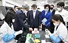 President Moon Jae-in, center, examines a Seegene research facility during his visit to the company’s headquarters in Seoul in March. Moon visited the local diagnostic kit manufacturing company following his phone conversation with U.S. President Donald Trump hours earlier. [YONHAP]