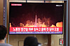 Passengers at Seoul Station on Sunday watch a television news broadcast about the North's early morning test of two short-range ballistic missiles (SRBM). [YONHAP]