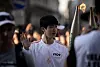 Jin carries the Olympic torch in Paris on July 14. [AP/YONHAP]