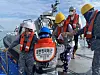 Helped by sailors, a resident from a remote island arrives on Korea's first military training vessel, Hansando, off Jin Island, South Jeolla, on Tuesday. The Navy has conducted an operation to help residents from remote islands, devoid of medical facilities, receive Covid-19 vaccine shots at a mass vaccination center installed on the ship. [YONHAP]