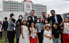 President Yoon Suk-yeol, center, takes a photo with Afghans settled in Korea at an event celebrating the presidential office’s move to Yongsan District in central Seoul Sunday. The event was attended by some 400 people including residents of the neighborhood, small merchants hit by Covid-19 and Afghans evacuated to Korea last year. [YONHAP]