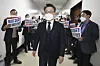 Anti-corruption watchdog chief Kim Jin-wook walks past opposition People Power Party (PPP) lawmakers on his way to a hearing at the National Assembly in Yeouido, Seoul on Thursday. [NEWS1]