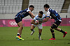 Argentina's Lautaro Bazan Velez, center, is challenged by Korea's Han Kun-kyu, left, and Coquillard Andre Jin in their men's rugby sevens match on Tuesday in Tokyo. [AP/YONHAP]