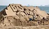 A foreign artist creates sand artwork of the K-pop boy band BTS at Haeundae Beach in Busan on Monday. The 2023 Haeundae Sand Festival, themed 'Expo Sand Sea for the Future of 2030,' will be held from Friday to Monday at Haeundae Beach and Gunam-ro Haeundae Square. [YONHAP]