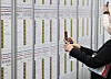 A job seeker takes photos of recruitment posters at job fair held in Suwon, Gyeonggi in October. [YONHAP]