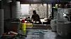 A restaurant owner watches the news in her empty establishment in Seodaemun District, western Seoul, on Wednesday, as the government announces its plans to implement much stricter social distancing measures. [YONHAP]