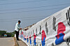 Abu Kowsir hangs a 3.5-kilometer (2.2-mile) Korean flag on a bridge near his home in Bancharampur, Bangladesh on Nov. 16.  [AFP/YONHAP]