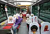 Models wave from inside a Seoul City Tour Bus parked at a bus station in Jung District, central Seoul, Thursday. The bus was decorated with characters from 'Bread Barbershop,' a Korean animated series, according to travel activities and services booking platform Klook on Thursday. The Bread Barbershop-themed city tour bus will start operation in April. [YONHAP]