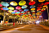 Visitors take photos at a road decorated with umbrellas next to Mallipo Beach in Taean County, South Chungcheong, on Wednesday night, after the road was designated as a pedestrian zone until July 30. [YONHAP]