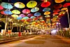 Visitors take photos at a road decorated with umbrellas next to Mallipo Beach in Taean County, South Chungcheong, on Wednesday night, after the road was designated as a pedestrian zone until July 30. [YONHAP]
