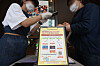 A worker at a coffee shop in Seoul scans a customer’s QR code on Monday as part of track-and-trace measures. [YONHAP]