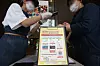 A worker at a coffee shop in Seoul scans a customer’s QR code on Monday as part of track-and-trace measures. [YONHAP]
