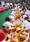 Volunteers make kimchi for socially vulnerable groups at the Namsangol Hanok Village in central Seoul on Tuesday. Hosted by Nonghyup, a total of 25,000 heads of kimchi including those made at the event will be delivered to various social welfare centers. [YONHAP]