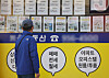 A man looks at notices of apartments on sale posted on a window at a realtor's office in Seoul on Sunday. While the government pressures banks to cut loans, trading of relatively cheap apartments in Seoul, priced under 600 million won ($510,000), is becoming popular, according to real estate app Zigbang on Sunday. [YONHAP]