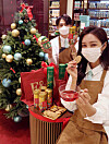 Models pose in front of a Christmas Tree with a holiday-edition tea from Fortnum & Mason on Thursday at a Shinsegae Department Store branch in Gangnam District, southern Seoul. The British tea maker will give out a free jute bag with every 100,000 won ($90) purchase. [SHINSEGAE DEPARTMENT STORE]