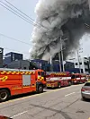 Smoke rise from Aricell, a lithium battery manufacturer in Seosin-myeon, Hwaseong, as fire trucks arrive at the scene. The fire erupted around 10:31 a.m. Monday. [NEWS1]