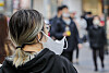 A pedestrian walks half-masked in the streets of Myeong-dong in Jung District, central Seoul, on March 29. [NEWS1]
