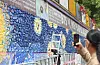 A fan takes a photo of BTS member V's mural in Daegu’s Seo District. [YONHAP]