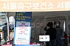 People stand in line to get tested for Covid-19 at a testing center near Seoul Station on Wednesday. [NEWS1]
