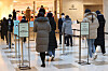 Visitors wait to show vaccine passes at the entrance of a department store in Seoul on Monday, one day before the vaccine pass program will be scrapped at six types of businesses nationwide, including department stores. [YONHAP]