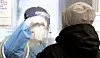A medical staff member takes a sample from a patient at Seoul Station on Monday. [NEWS1]