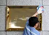 An employee cleans the Ministry of Unification signboard in front of the central government complex in Gwanghwamun, central Seoul. [JOONGANG PHOTOS]