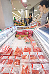 Customers check out the sliced watermelon section at a supermarket in Seoul on June 16. [YONHAP]