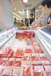 Customers check out the sliced watermelon section at a supermarket in Seoul on June 16. [YONHAP]