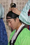 A man has his hair tied up in a topknot during a traditional coming-of-age ceremony held at the Gwangju Hyanggyo, a state-owned Confucianism school in Gwangju, Wednesday. [YONHAP]