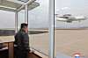 North Korean leader Kim Jong-un watches an aircraft that appears to be an airborne early warning and control aircraft flying as he guides the defense science research work of the Unmanned Aeronautical Technology Complex and the detective electronic warfare research group, in this undated photo released by the North's official Korean Central News Agency on March 27. The guidance took place on March 25 to 26. [YONHAP]