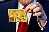 President Donald Trump holds up “The Trump Card” as he speaks to reporters aboard Air Force One on his way to Florida, April 3, 2025. Members of Elon Musk’s government-slashing task force are building a system for the United States to sell special immigration visas, which Trump has labeled “gold cards,” for $5 million apiece. (Eric Lee/The New York Times)