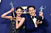 Lee Jung-Jae, right, accepts the award for outstanding performance by a male actor in a drama series for ″Squid Game″ at the 28th annual Screen Actors Guild Awards at the Barker Hangar on Sunday, Feb. 27, 2022, in Santa Monica, Calif. Hoyeon won outstanding female actor. [AP]
